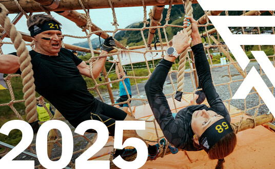 A group of athletes dressed in black are running towards the camera. ‘2025’ is written in white at the bottom right. The Arlberger Wadlbeisser logo can be seen as a design element at the top left.