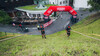 Athleten ziehen sich via Tau einen steilen Grashang hinauf / Athletes pull themselves up a steep grassy slope using ropes.