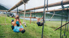 Athleten hangeln sich kopfüber den Tauen entlang / Athletes swing headfirst along the ropes